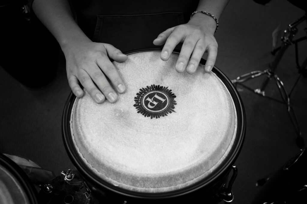 pexels-photo-65717-65717 A black and white close-up shot of hands drumming on a bongo drum, emphasizing rhythm and music.